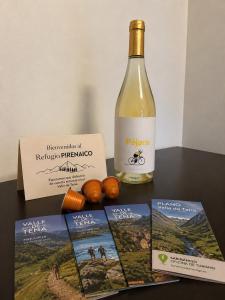 a bottle of wine next to a bottle of wine and a box at Refugio PIRENAICO in Sabiñánigo