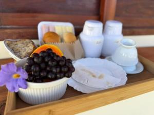 a tray with a plate of food and a bowl of fruit at Brisa da Mata suítes BF in Baía Formosa +9 photos