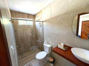 a bathroom with a shower and a toilet and a sink at Brisa da Mata suítes BF in Baía Formosa