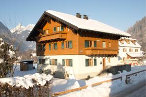 シュルンスにあるLandhaus Grütの雪の大木造住宅