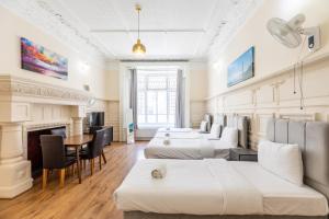 a hotel room with four beds and a fireplace at The Hyde Hotel in London +46 photos