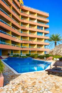 a hotel with a swimming pool in front of a building at Apartamento vacacional pampatar in Pampatar