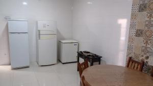 a kitchen with two refrigerators and a table in a room at Estância Bonanzza Barretos in Barretos