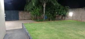 a backyard at night with a green lawn at Estância Bonanzza Barretos in Barretos