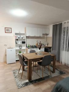 a kitchen and dining room with a table and chairs at Studio apartman EMA in Brodski Varoš