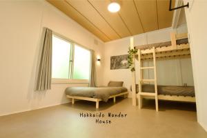 a bedroom with two bunk beds and a window at Hokkaido Wander House in Ashibetsu