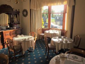 ein Esszimmer mit 2 Tischen und einem Fenster in der Unterkunft Craignay Guest House in Inverness