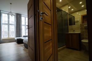 baño con ducha y puerta a una habitación en Apartament MARIACKA 42, en Gdansk 7 fotos más
