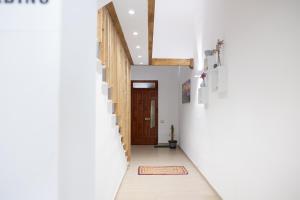 a hallway with white walls and a wooden door at GioLì in Matino