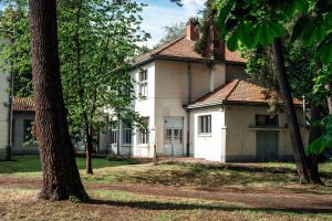 an old white house with trees in front of it at ReCenter in Brecht