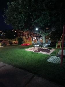 a park at night with a table and a swing at Studio apartman EMA in Brodski Varoš