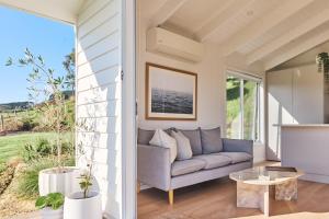 a living room with a couch and a table at Drift, Port Campbell in Port Campbell