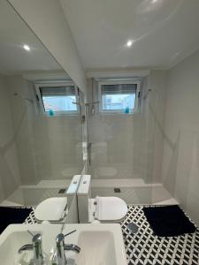 a bathroom with two toilets and a sink and a shower at Dormitorio no Porto in Porto
