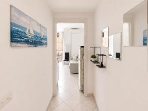 a living room with a painting of a sailboat on the wall at Casa DELUXE -50m dal mare- in Alassio