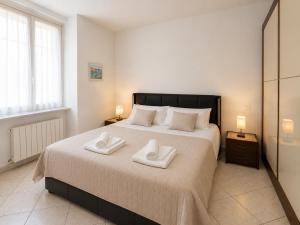 a bedroom with a large bed with two towels on it at Casa DELUXE -50m dal mare- in Alassio