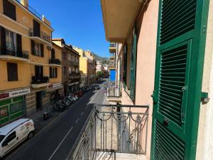 an apartment balcony with a green door and a street at Casa DELUXE -50m dal mare- in Alassio