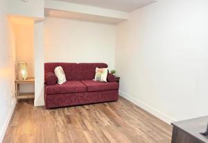 a living room with a red couch in the corner at Victoria BNB in Victoria