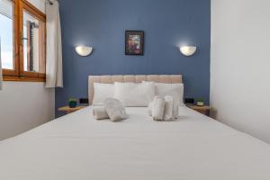 a bedroom with a large white bed with two pillows at Hotel Sarikas in Polychrono +66 photos