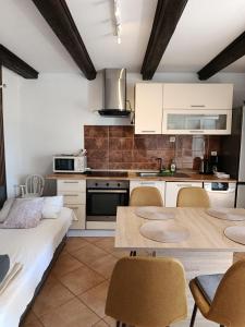 a kitchen with white cabinets and a table and chairs at Apartmani Gero in Lopar