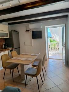 a kitchen and dining room with a table and chairs at Apartmani Gero in Lopar