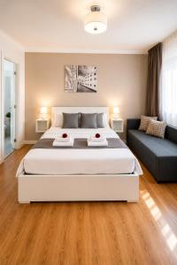 a bedroom with a large white bed and a couch at Corso Venezia in Mestre