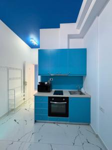 a kitchen with blue cabinets and a stove at Romance Apartments in Sarandë