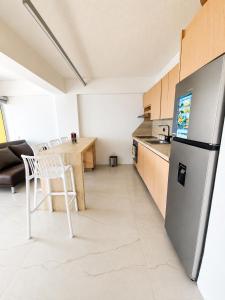 a kitchen with a table and a refrigerator at Apartamento vacacional pampatar in Pampatar