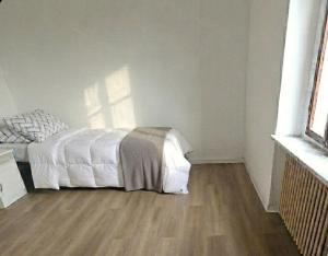 a bedroom with a white bed and a wooden floor at b apartments in Case Bruciate