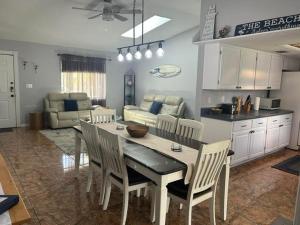 a kitchen and living room with a table and chairs at Blue Beach Pool House in Port Orange