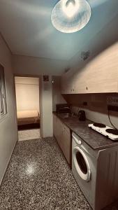 a kitchen with a sink and a washer in it at Loutraki Suites in Loutraki