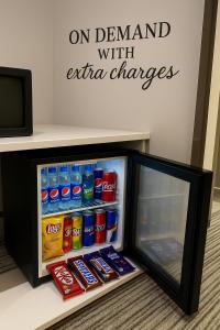 a small refrigerator with soda and drinks in it at THREE TREE Signature Hotel - G7 Markaz Islamabad in Islamabad
