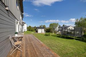 a deck with a bench on the side of a house at Apartment in Tromsdalen in Tromsø +2 photos