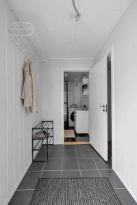 a hallway with white walls and a tile floor at Apartment in Tromsdalen in Tromsø