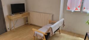 a room with a tv and a chair and a desk at Proche de la gare in Saint-Jean-Pied-de-Port