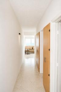 a hallway with white walls and a white floor at Apartamento vacacional pampatar in Pampatar