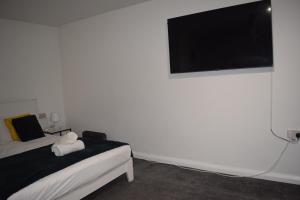 a bedroom with a bed and a flat screen tv at Studio Apartment Fully Equipeed with WiFi and Netflix in Ilkeston