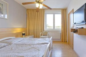 un dormitorio con una cama y un ventilador de techo en Hotel Monaco, en Náměšť nad Oslavou