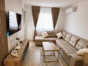a living room with a couch and a table at Tulipan LUX in Doboj