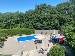an overhead view of a pool with chairs and an umbrella at Guesthouse Vionica - Peace & Pool in Međugorje