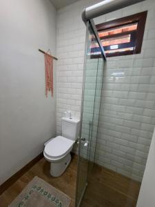 a bathroom with a toilet and a glass shower at Chalé Brisa da Mata Baia Formosa in Baía Formosa +8 photos