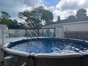 a large swimming pool with chairs in it at Blue Beach Pool House in Port Orange