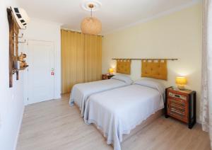 a bedroom with two beds and a night stand with two lamps at Lumae Guesthouse in Lobres +6 photos