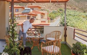 a man standing on a balcony with a table and a dog at Lumae Guesthouse in Lobres