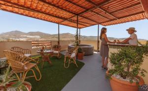 a man and a woman standing at a bar on a balcony at Lumae Guesthouse in Lobres