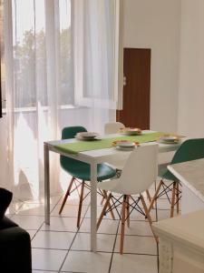 a dining room with a green table and chairs at Casa Mansi in Vietri sul Mare