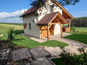 a house with a pitched roof and a patio at Nad Drwęcą in Mszano