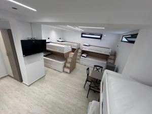 a room with two beds and a tv and a table at Ferra Hostel in Durrës