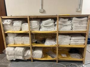 a shelf filled with lots of white towels at Ferra Hostel in Durrës +30 photos