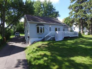 a small blue house on a grassy yard at Dartt's Park Flat in Owatonna