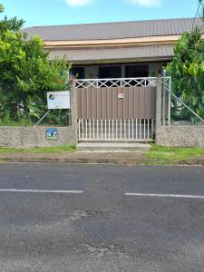 a gate in front of a house with a building at City Cottage Suva in Suva